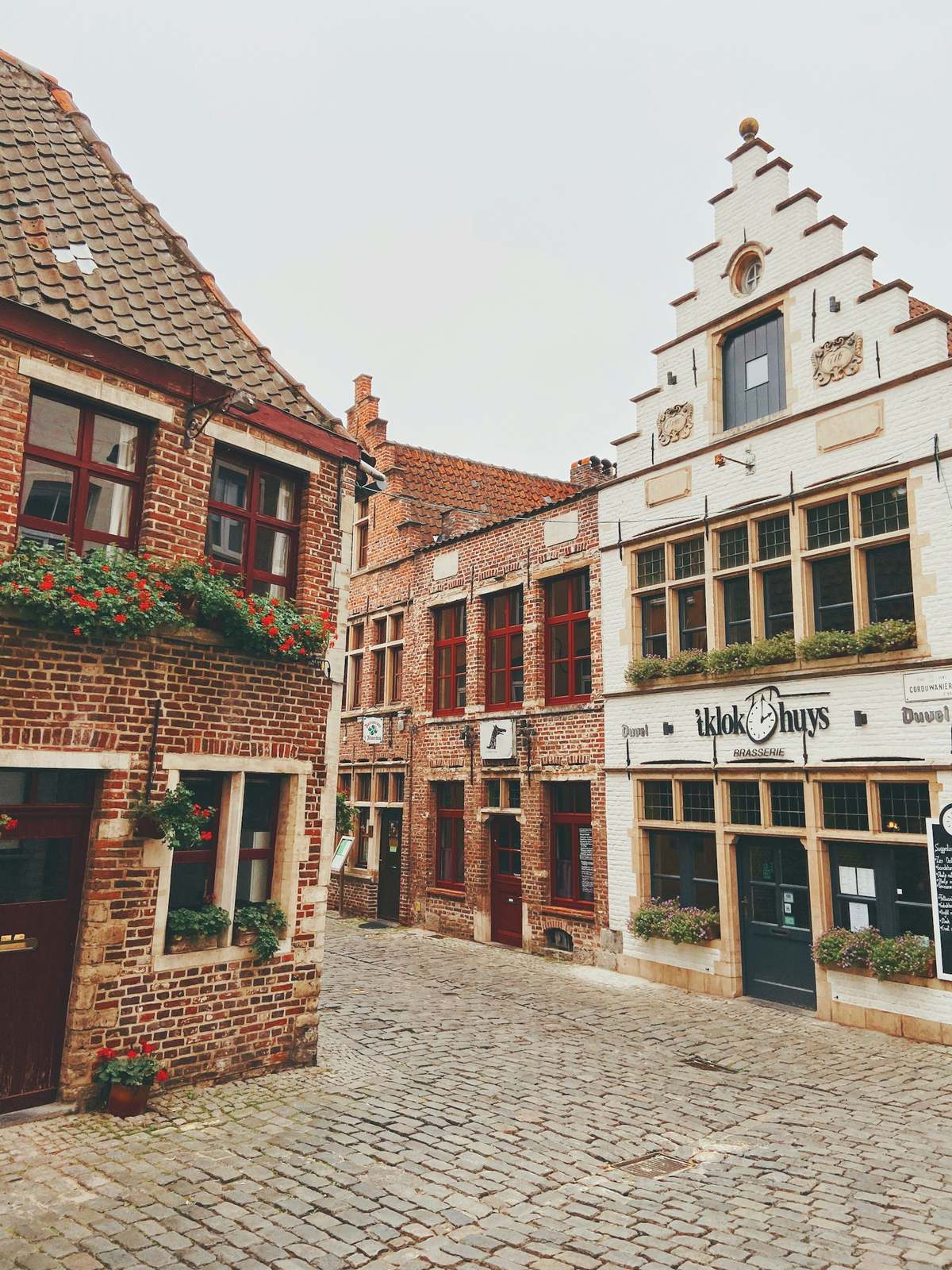 Kasseistraat met bakstenen huizen en een witte trapgevel