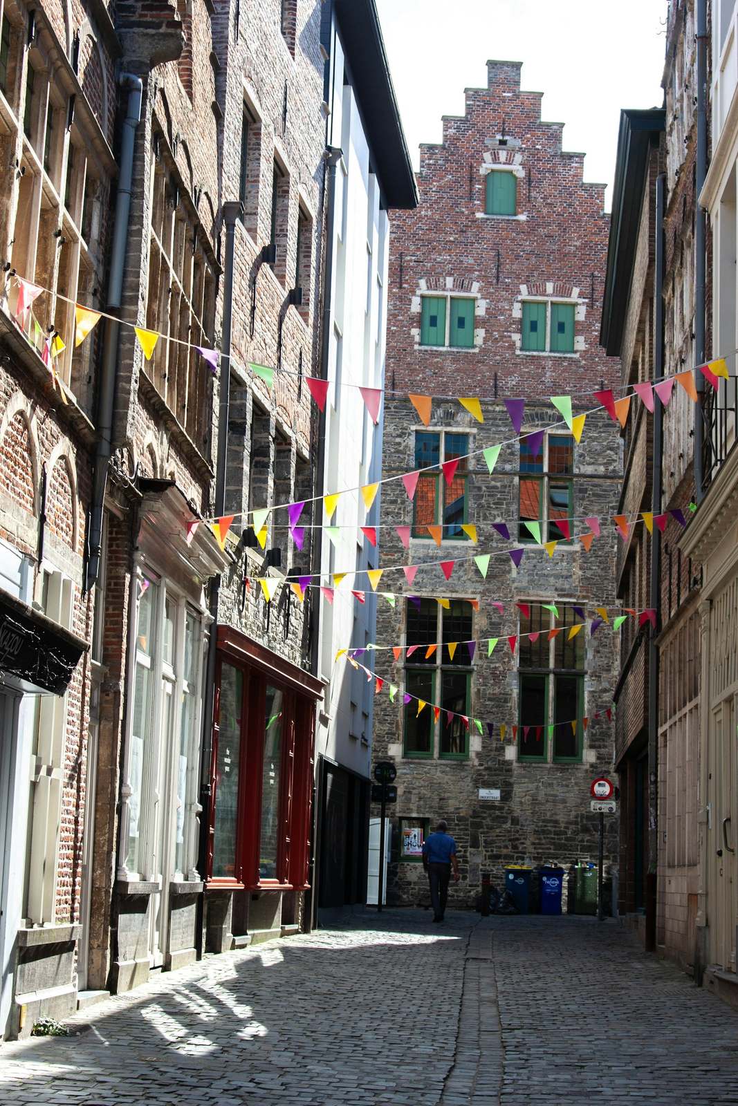 Smalle straat met vlaggetjes tussen de gevels en een trapgevel aan het einde